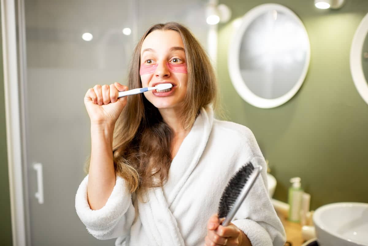 woman-brushhing-teeth-in-the-bathroom-2021-12-09-04-39-58-utc